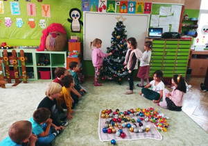 Dzieci ubierają grupową choinkę.